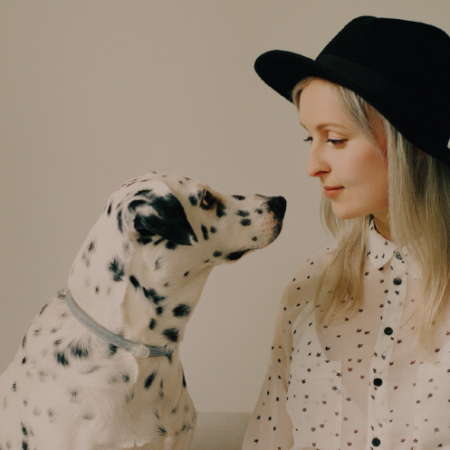 blonde woman in hat petting Dalmatian dog